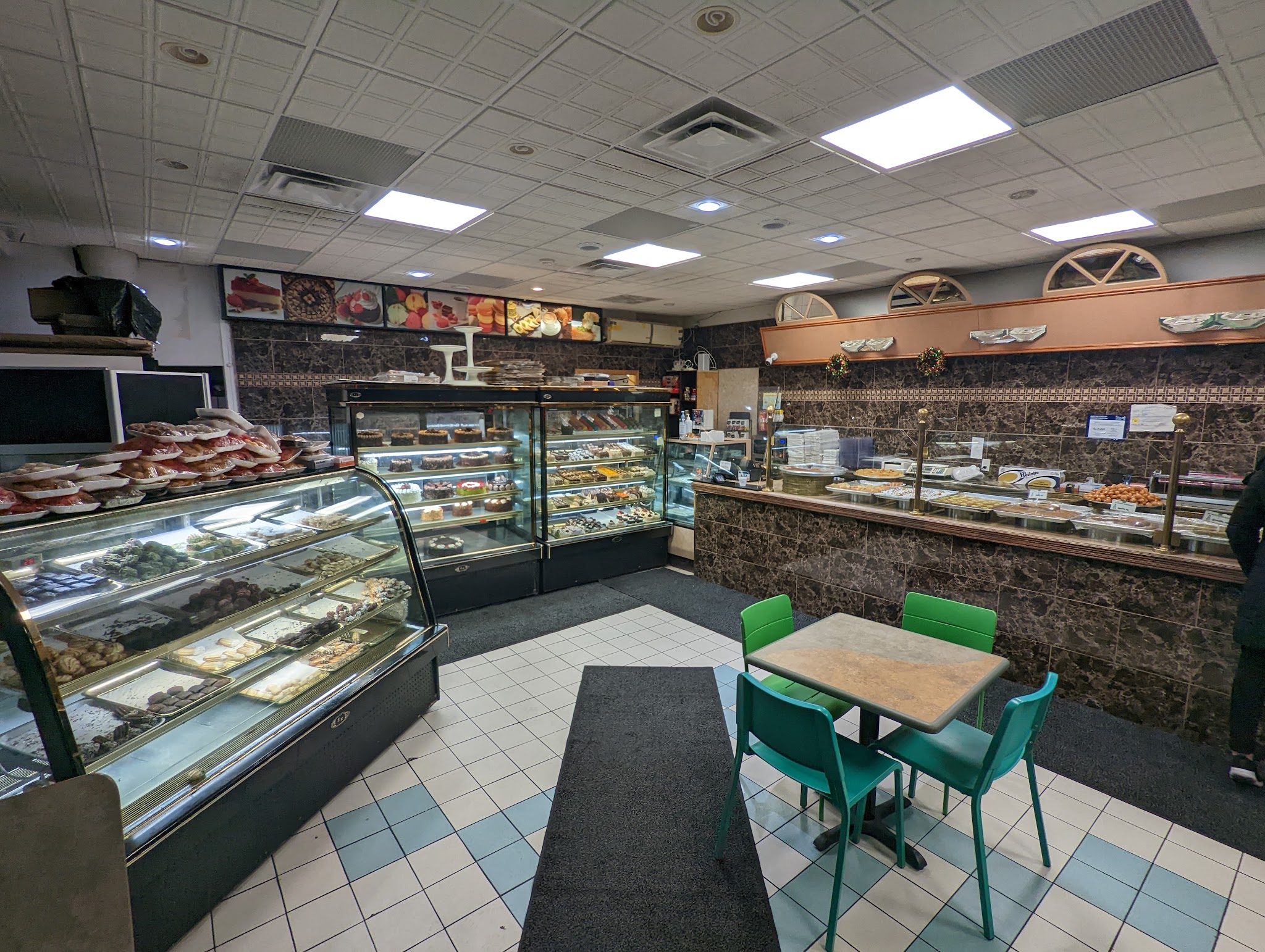 Inside La Brioche bakery showing glass display cases filled with pastries, the marble-accented counter, and cozy seating area