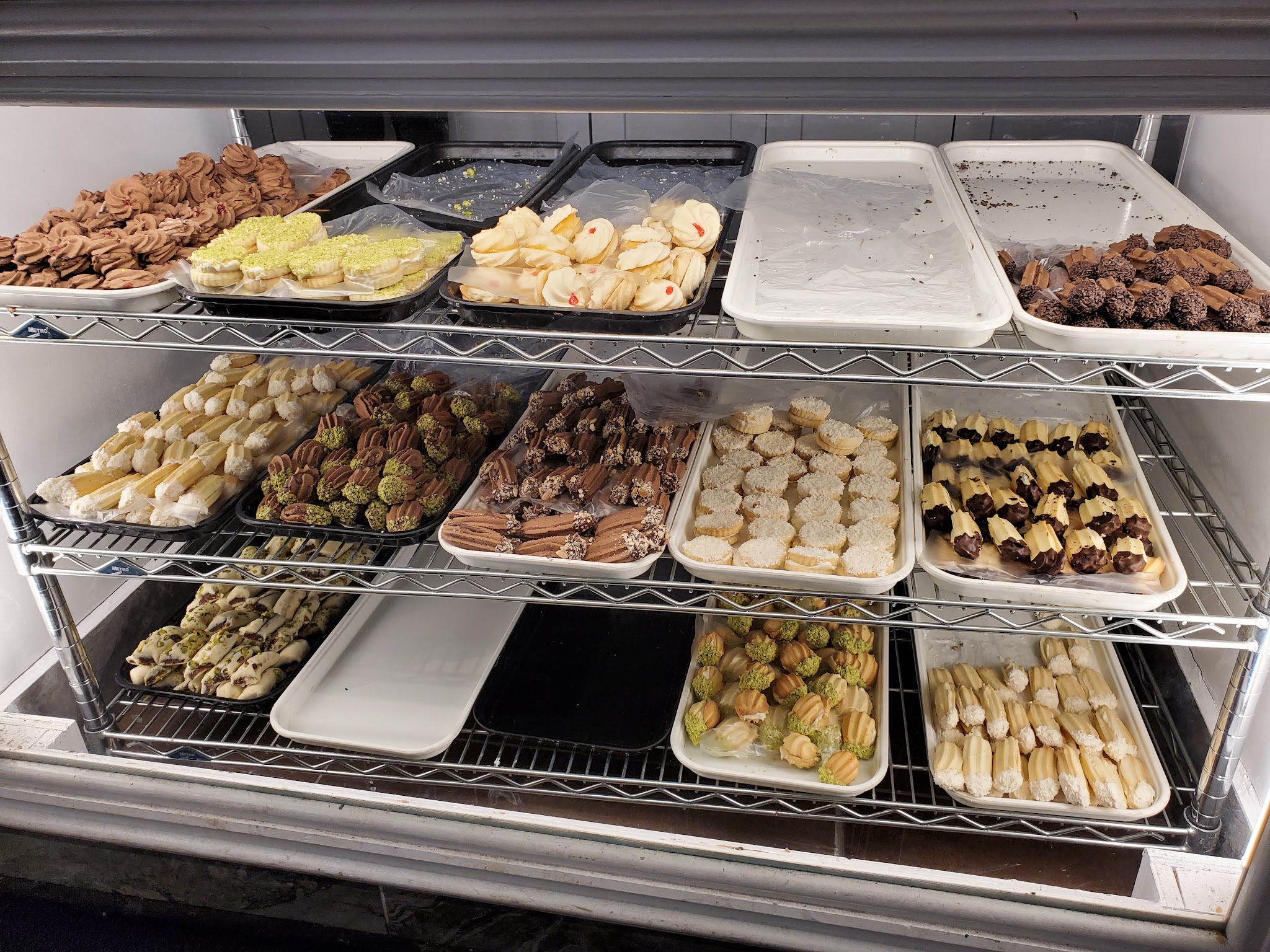 Petit fours production shelves with rows of decorated pastries